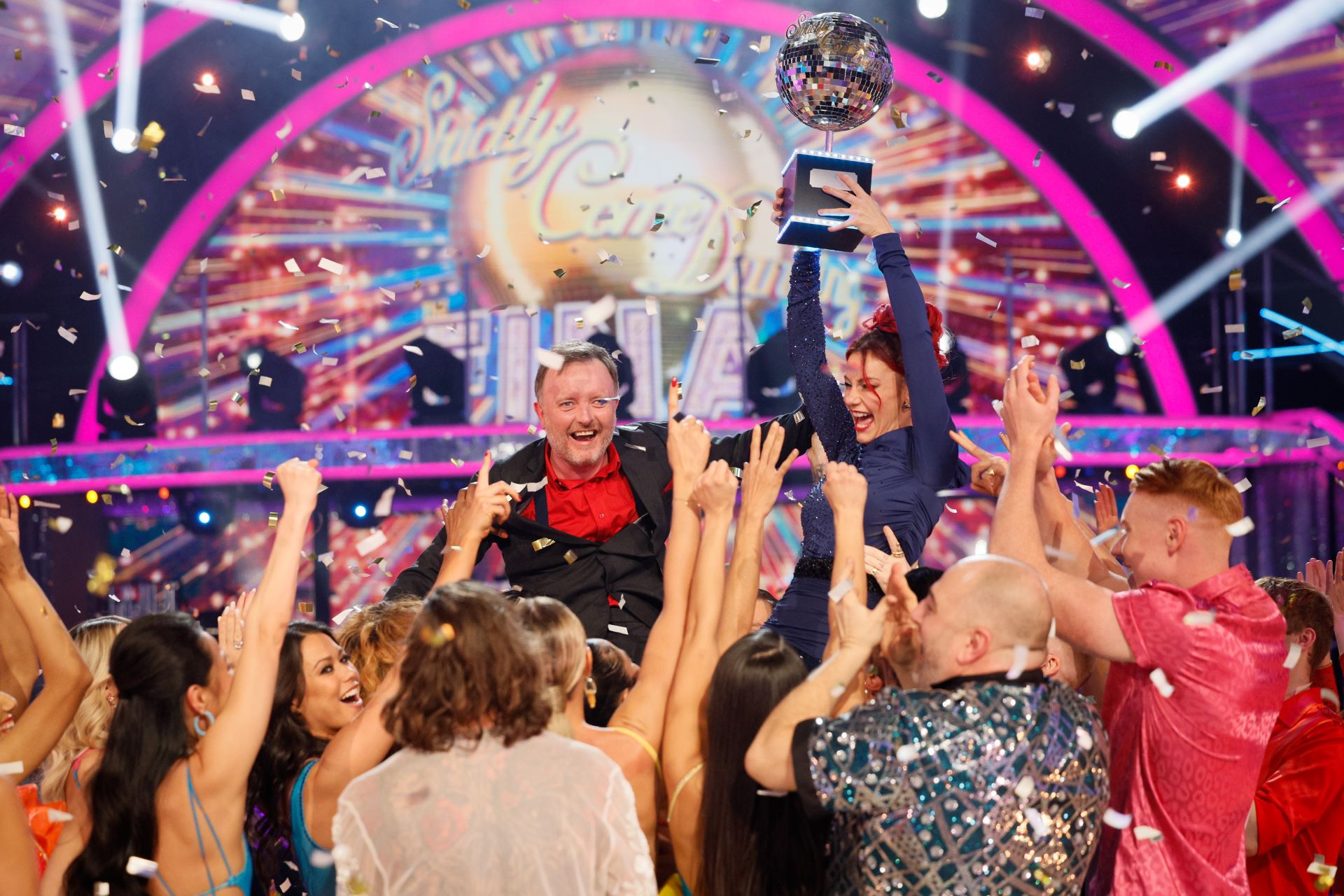 Production shot of Strictly Come Dancing 2024 winners being held aloft with the glitterball trophy